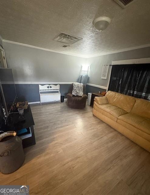 living room featuring crown molding, a textured ceiling, and wood-type flooring