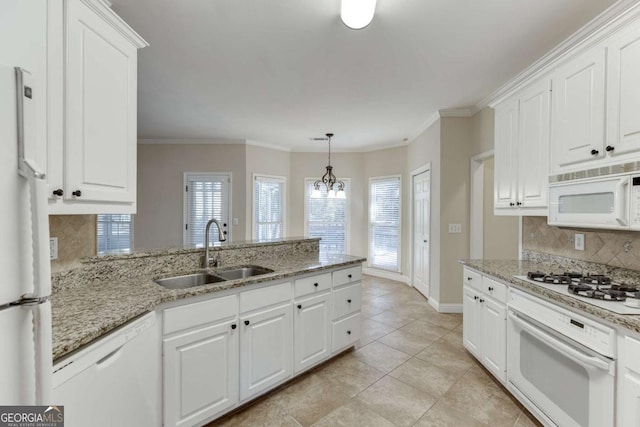 kitchen featuring white appliances, tasteful backsplash, white cabinetry, sink, and decorative light fixtures