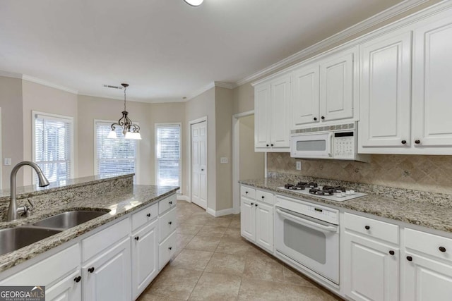 kitchen featuring white appliances, pendant lighting, white cabinetry, sink, and crown molding