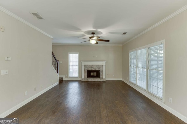 unfurnished living room featuring ceiling fan, a brick fireplace, ornamental molding, and dark hardwood / wood-style flooring