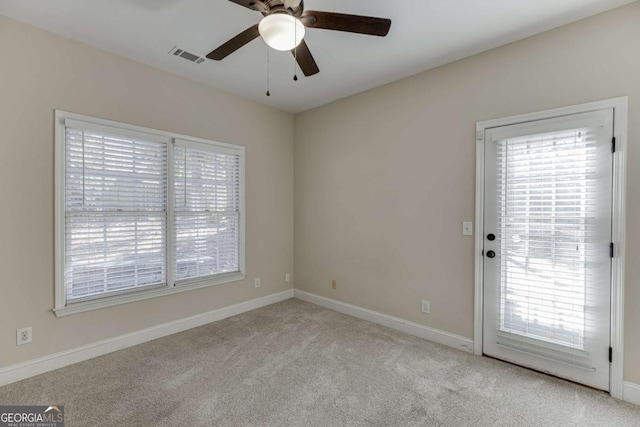 carpeted spare room featuring ceiling fan