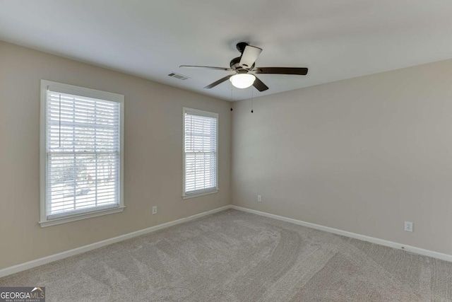 carpeted spare room featuring ceiling fan