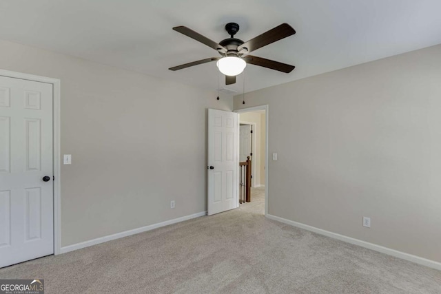 carpeted spare room featuring ceiling fan