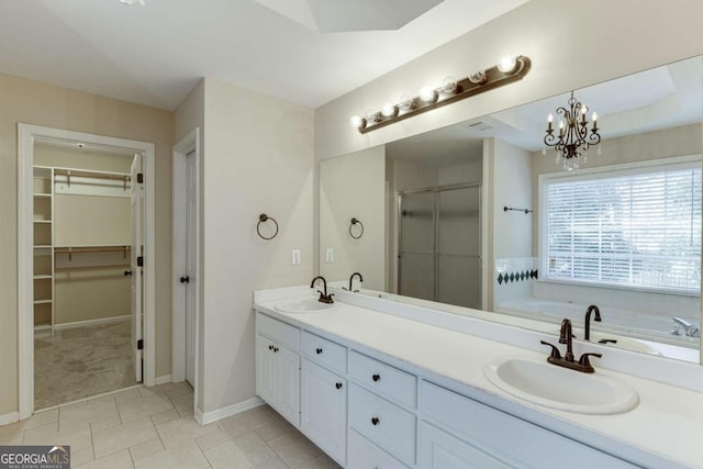 bathroom with vanity, a notable chandelier, tile patterned flooring, and plus walk in shower