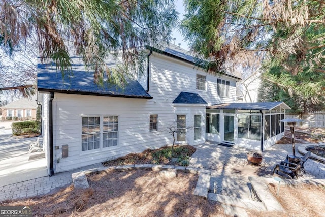 rear view of property featuring a sunroom and a patio