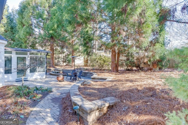 view of yard with a sunroom and a patio