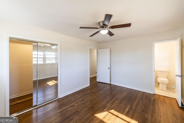 unfurnished bedroom with dark hardwood / wood-style floors, a closet, ceiling fan, and connected bathroom