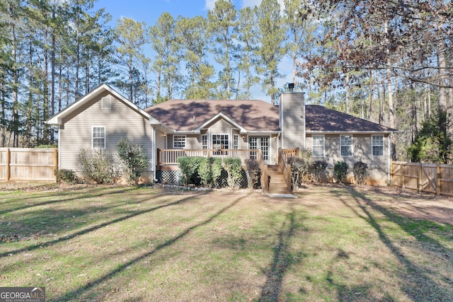 rear view of property with a yard and a deck