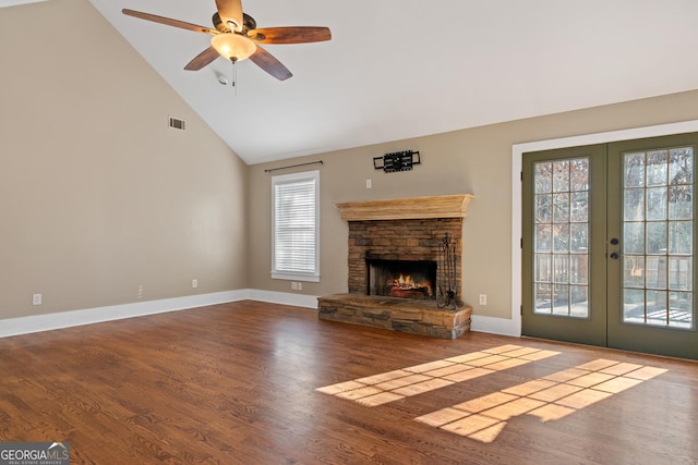 unfurnished living room featuring french doors, wood-type flooring, high vaulted ceiling, ceiling fan, and a fireplace