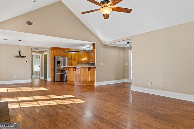 unfurnished living room with hardwood / wood-style floors, high vaulted ceiling, and ceiling fan