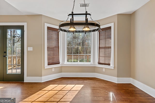 unfurnished dining area with wood-type flooring and a wealth of natural light