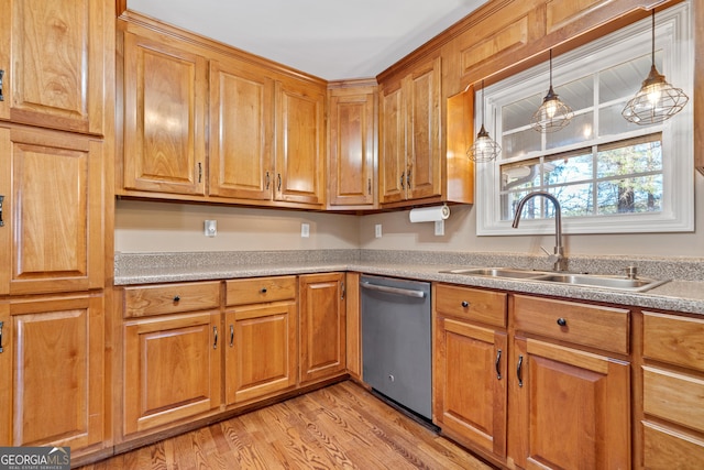 kitchen featuring pendant lighting, sink, stainless steel dishwasher, and light wood-type flooring