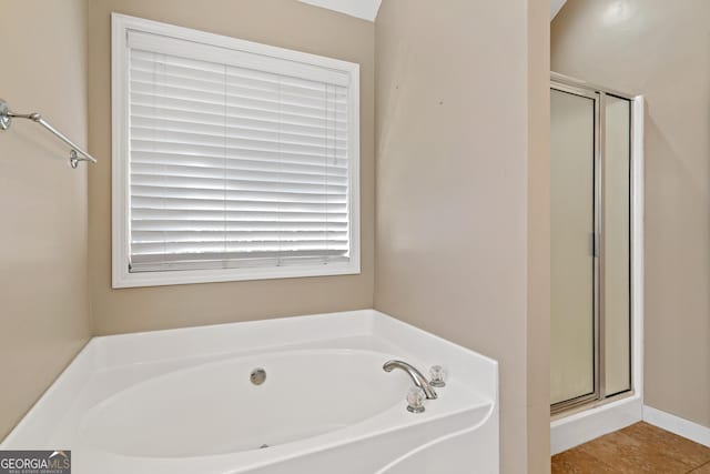 bathroom featuring shower with separate bathtub