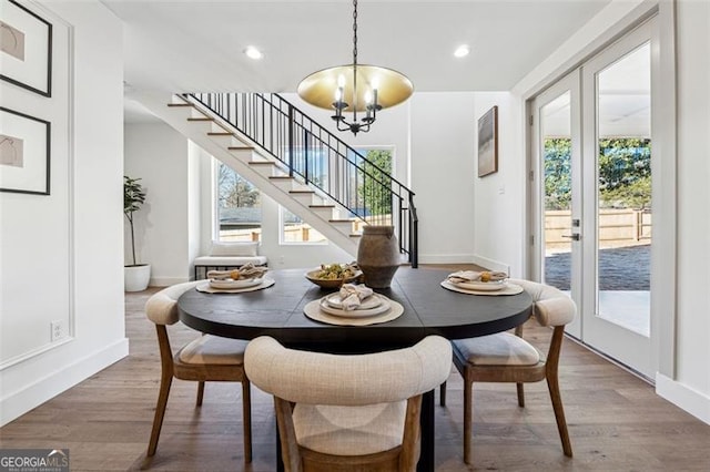 dining space with french doors, a chandelier, and wood-type flooring