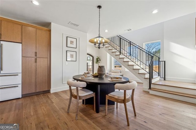 dining area featuring light wood-type flooring and a chandelier