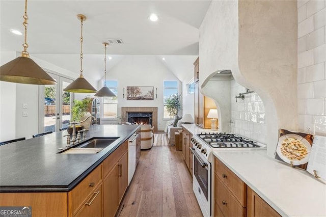 kitchen featuring vaulted ceiling, sink, decorative light fixtures, a wealth of natural light, and white appliances