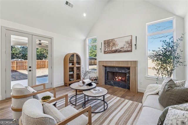 living room featuring french doors, a healthy amount of sunlight, and light hardwood / wood-style flooring