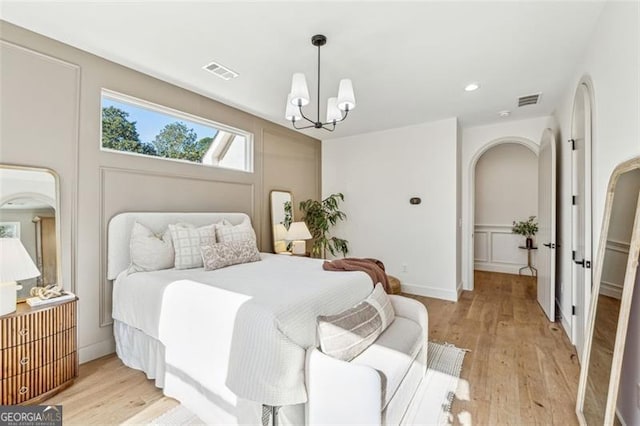 bedroom with an inviting chandelier and light hardwood / wood-style floors