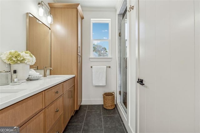 bathroom featuring crown molding, a shower with shower door, tile patterned floors, and vanity