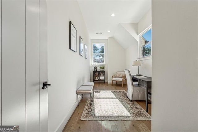 additional living space with hardwood / wood-style flooring and vaulted ceiling