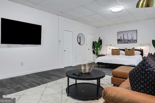 bedroom featuring dark wood-type flooring and a paneled ceiling