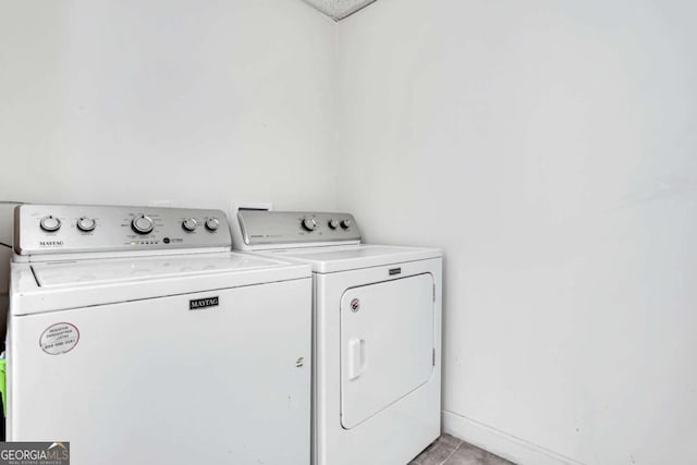 clothes washing area with light tile patterned floors and separate washer and dryer