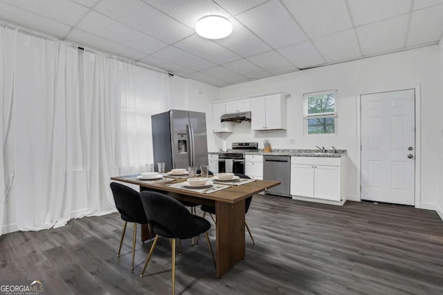 dining room with sink, a paneled ceiling, and dark hardwood / wood-style flooring