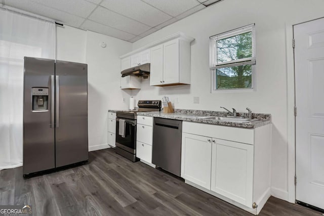 kitchen featuring appliances with stainless steel finishes, dark wood-type flooring, white cabinetry, sink, and a drop ceiling