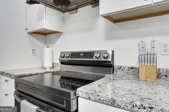 kitchen featuring white cabinetry and electric stove