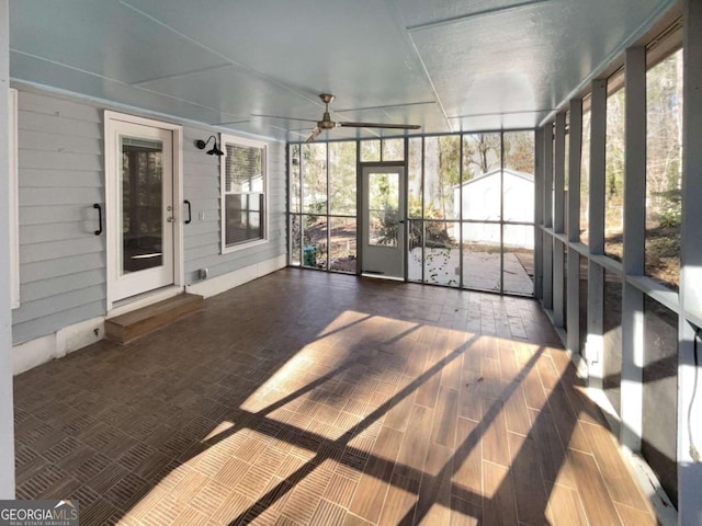 unfurnished sunroom featuring ceiling fan