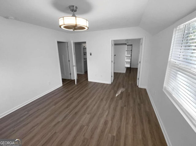 unfurnished bedroom featuring a closet, vaulted ceiling, and dark hardwood / wood-style flooring