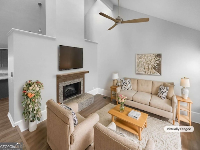 living room featuring ceiling fan, hardwood / wood-style flooring, a high end fireplace, and lofted ceiling