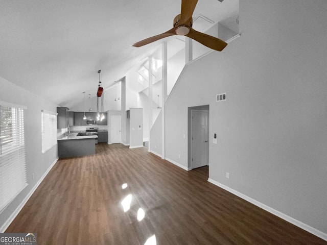 unfurnished living room featuring ceiling fan, dark hardwood / wood-style floors, and high vaulted ceiling