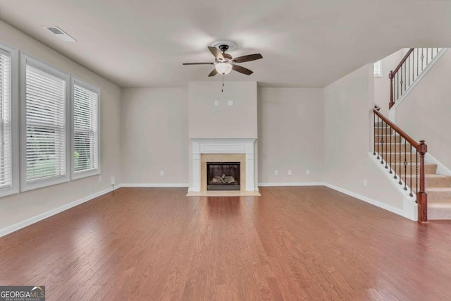 unfurnished living room featuring a fireplace, hardwood / wood-style floors, and ceiling fan