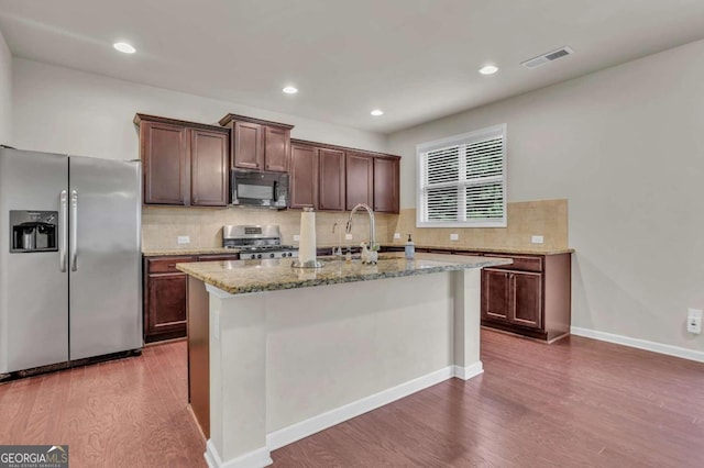 kitchen featuring sink, a center island with sink, dark wood-type flooring, and stainless steel appliances