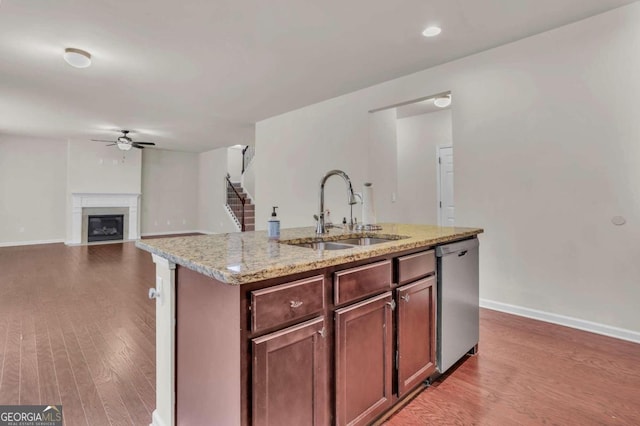 kitchen featuring ceiling fan, light hardwood / wood-style floors, stainless steel dishwasher, sink, and an island with sink