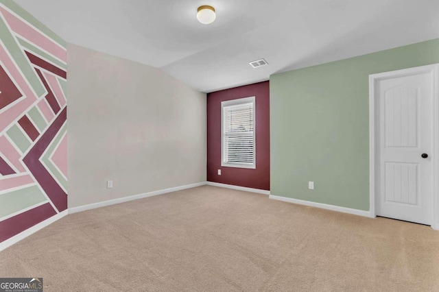 carpeted spare room with lofted ceiling