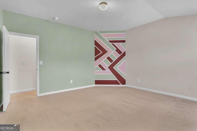carpeted spare room featuring lofted ceiling