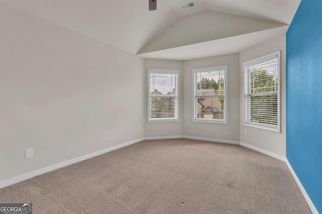 spare room with ceiling fan, light colored carpet, and lofted ceiling
