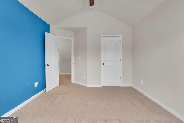 unfurnished bedroom with light carpet and vaulted ceiling