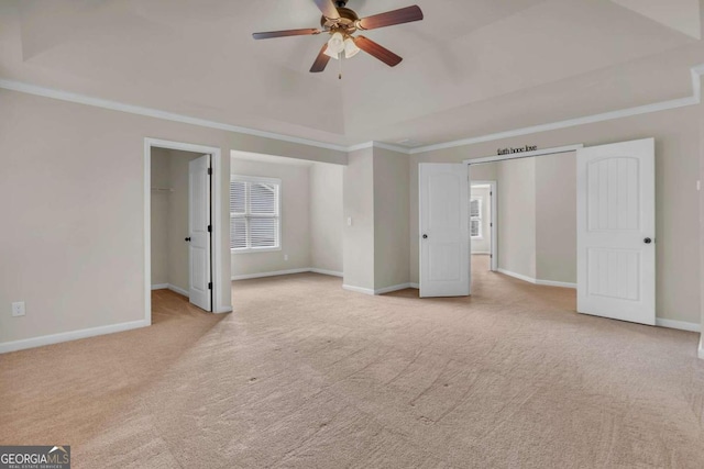 interior space with light carpet, vaulted ceiling, ceiling fan, and crown molding