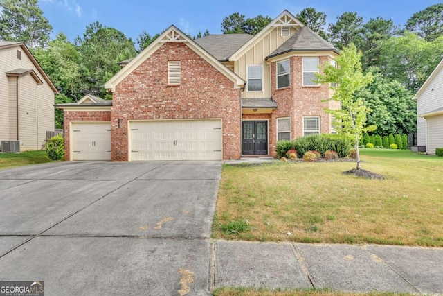 view of front of home with a garage, cooling unit, and a front yard