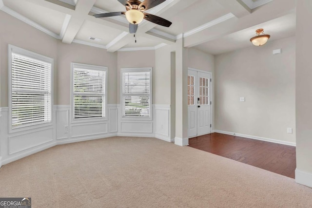 carpeted empty room with crown molding, coffered ceiling, beam ceiling, and ceiling fan