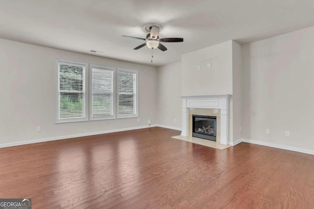 unfurnished living room featuring ceiling fan, hardwood / wood-style flooring, and a fireplace