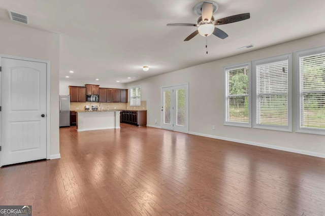 unfurnished living room with dark wood-type flooring and ceiling fan