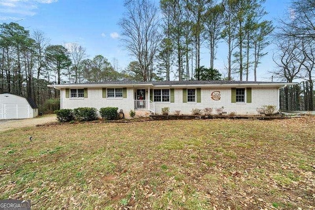 ranch-style house with a front yard, a porch, and a storage unit