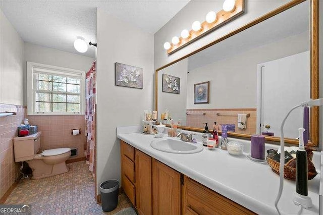 bathroom with toilet, tile patterned flooring, and vanity