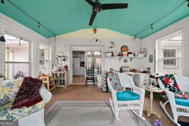 interior space featuring ceiling fan, wood-type flooring, plenty of natural light, and lofted ceiling