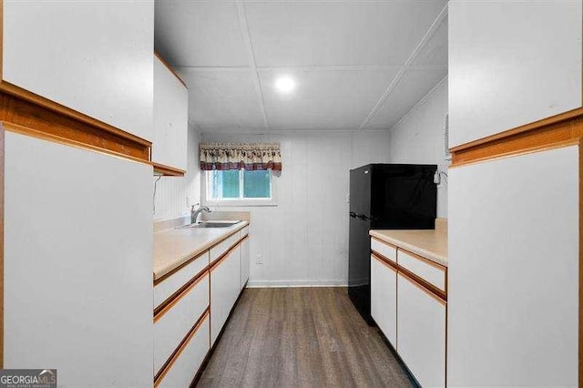 kitchen with sink, white cabinetry, and wood-type flooring