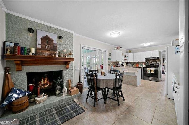 dining room with sink, ornamental molding, a fireplace, and light tile patterned flooring